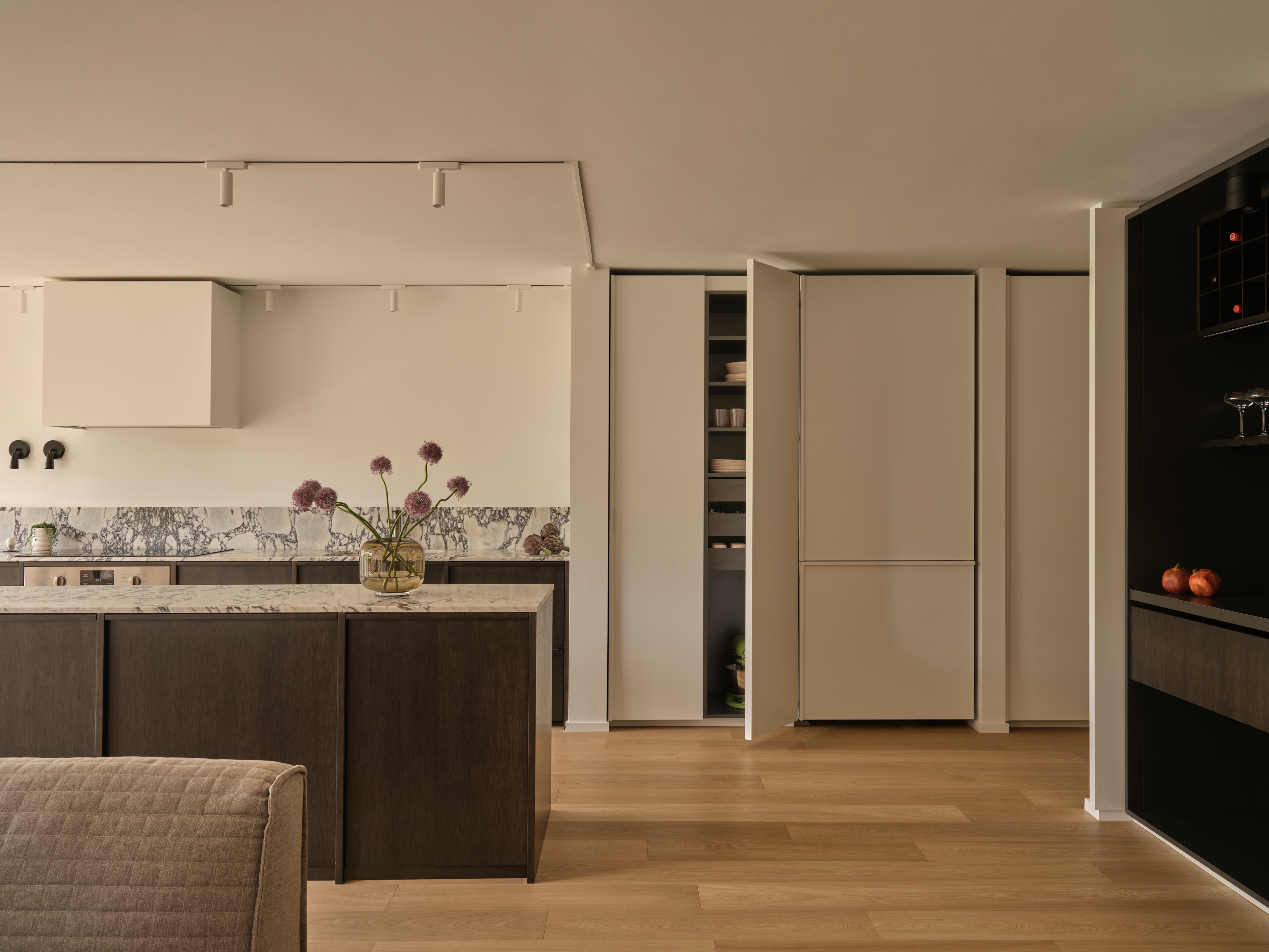 Renovated kitchen with dark wood cabinetry and Calacatta Viola marble island
