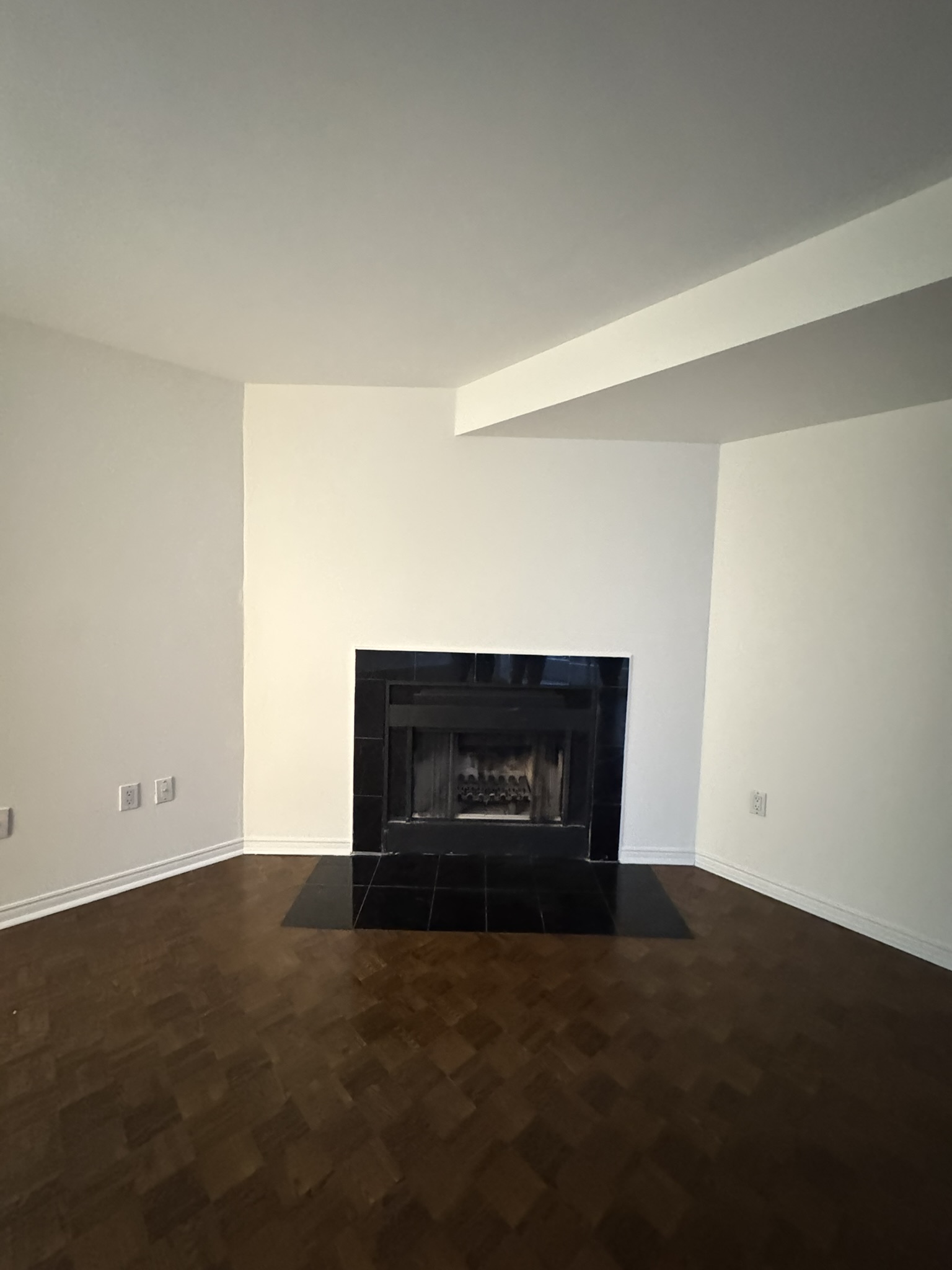 Original corner fireplace with dated black tile surround before renovation